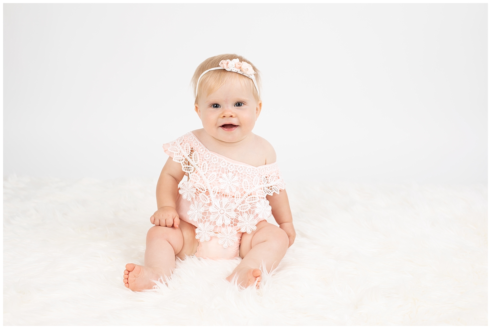 Peach romper with white flower lace on a baby girl