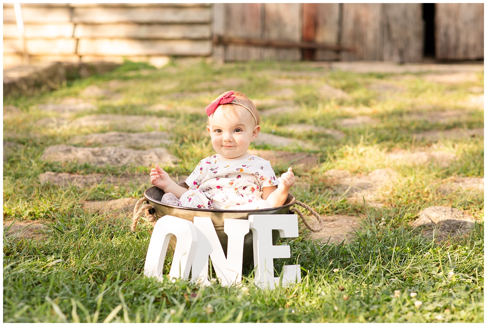 one year old girl sitting in a galvanized tub with wooden one letters