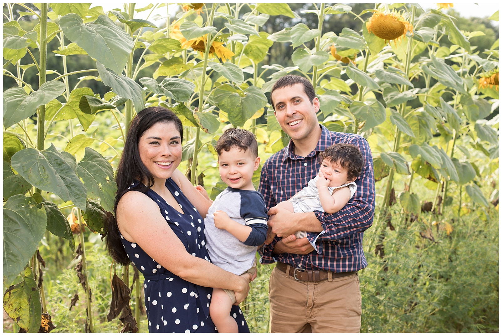 family smiling in sunflower field