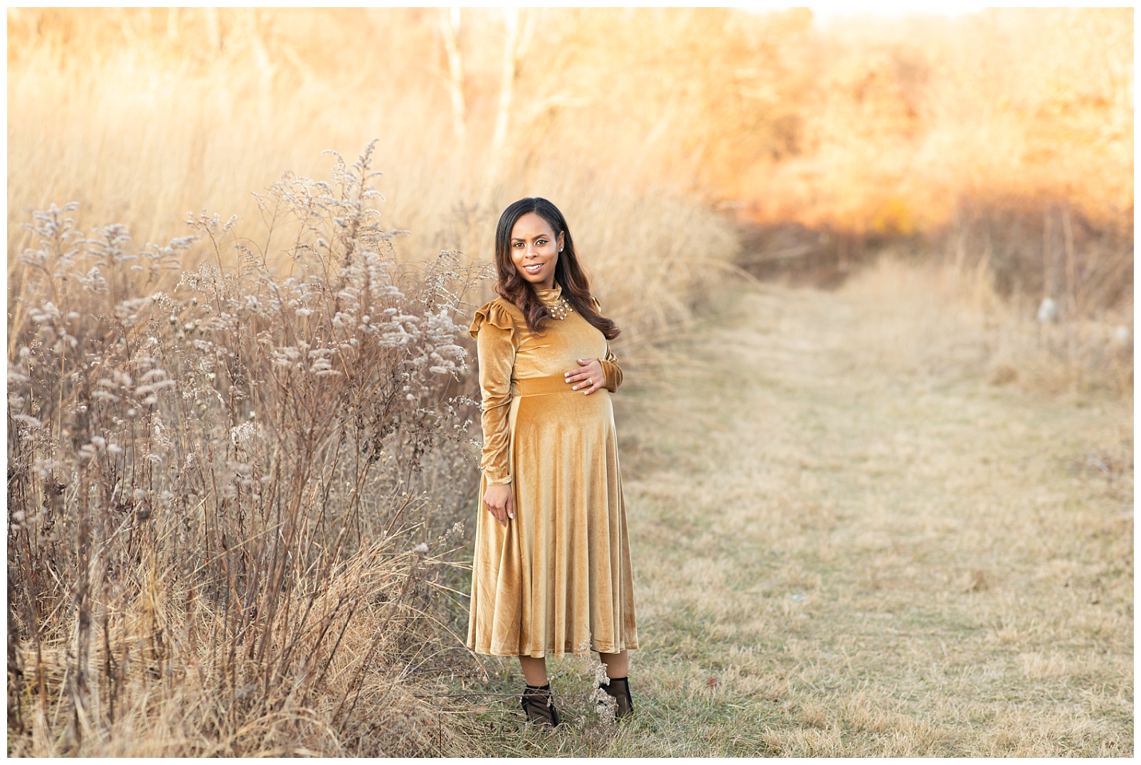 Lady wearing a gold dress standing in a field