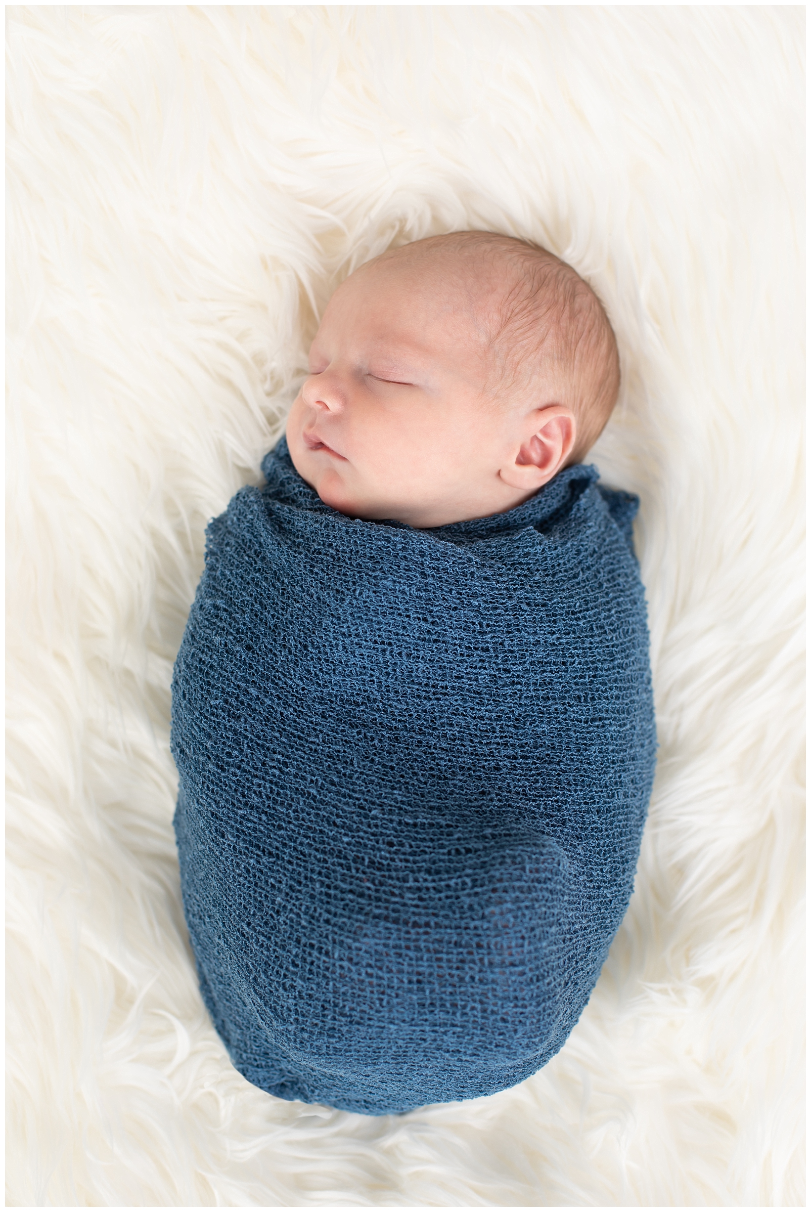 newborn boy in blue wrap