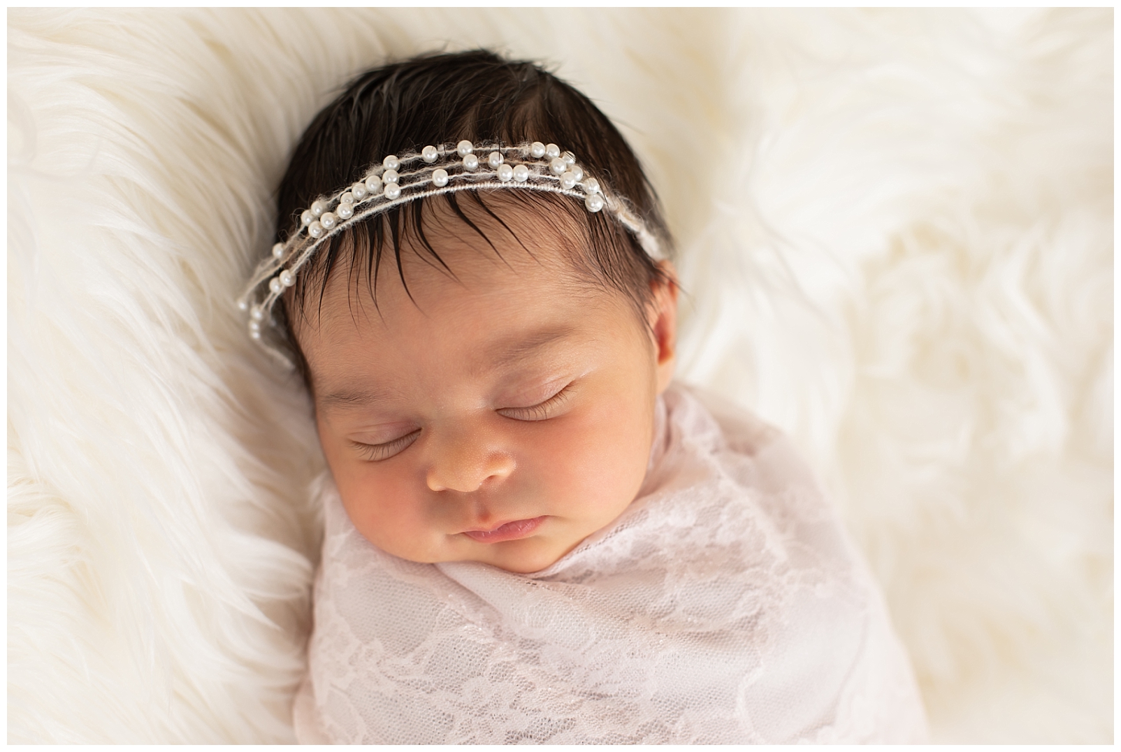 newborn girl with pearl headband and pink lace wrap