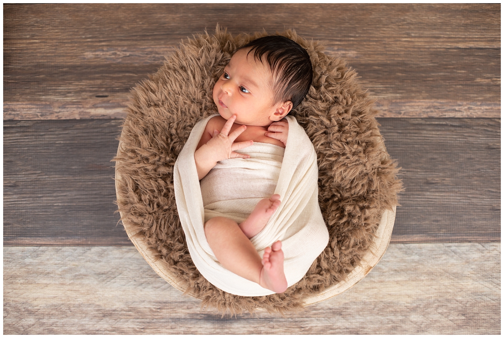 newborn in basket with wrap