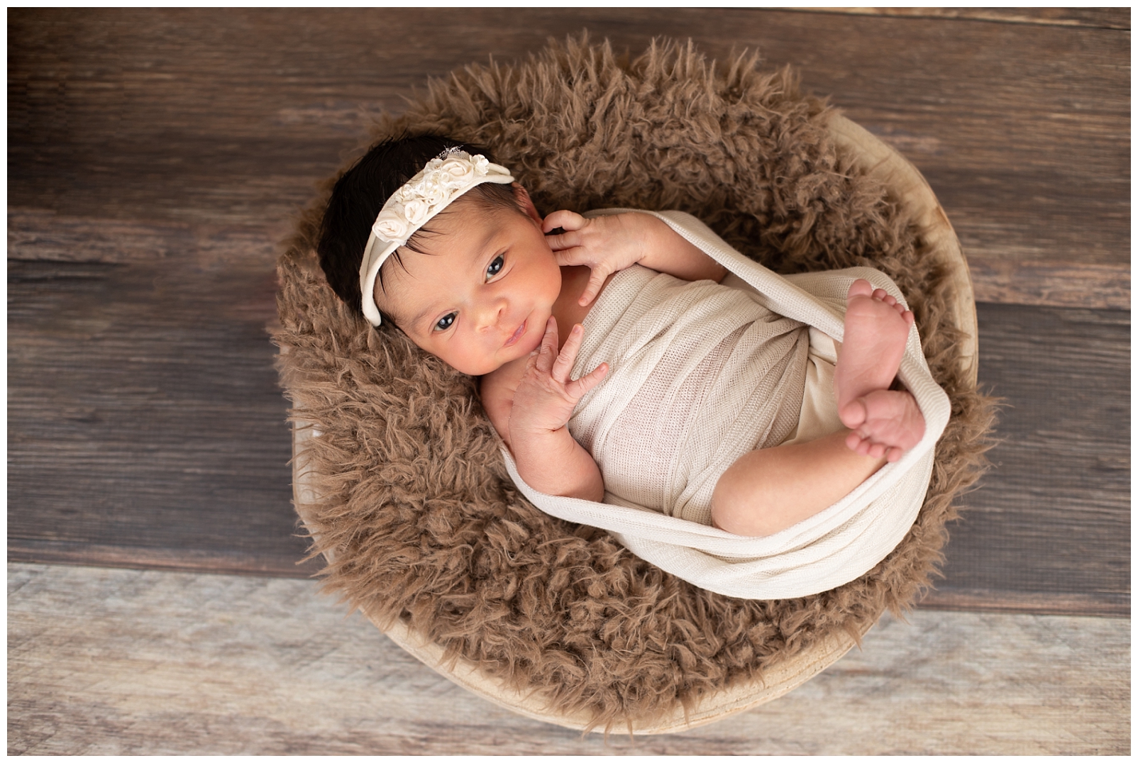 newborn girl in basket with floral headband