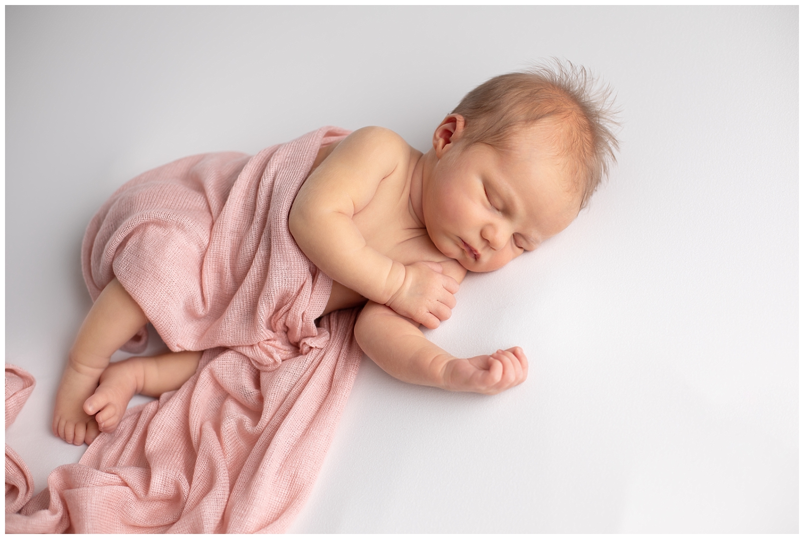 Newborn girl in pink wrap 