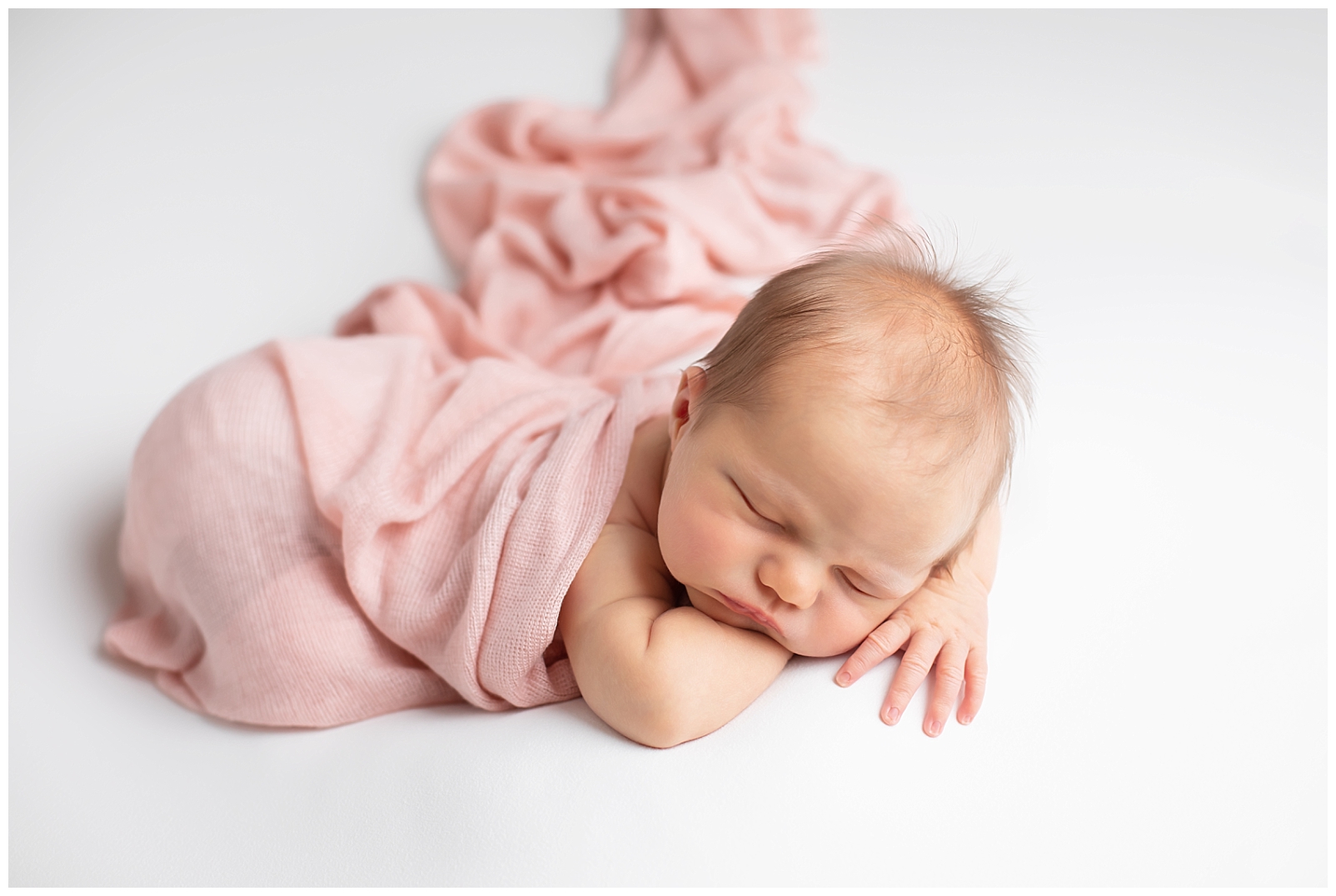 Newborn girl in pink wrap