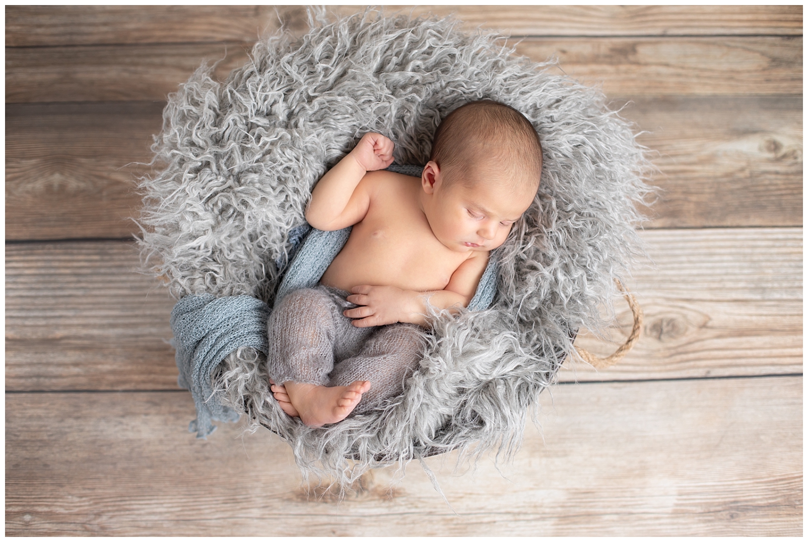 newborn wrapped in gray on back