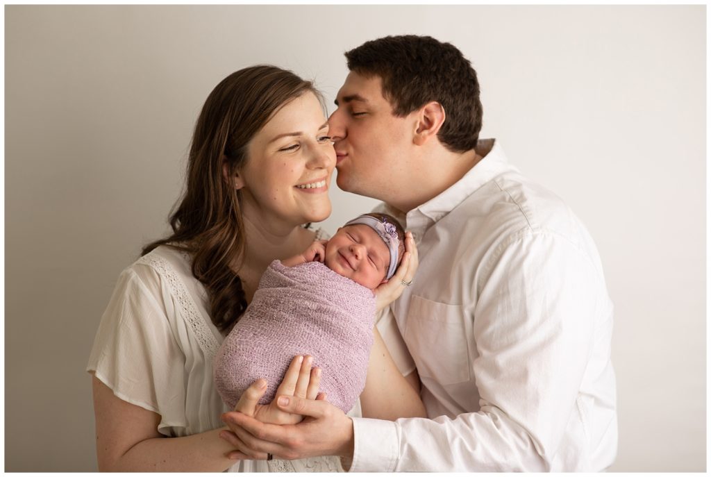 newborn smiling with parents