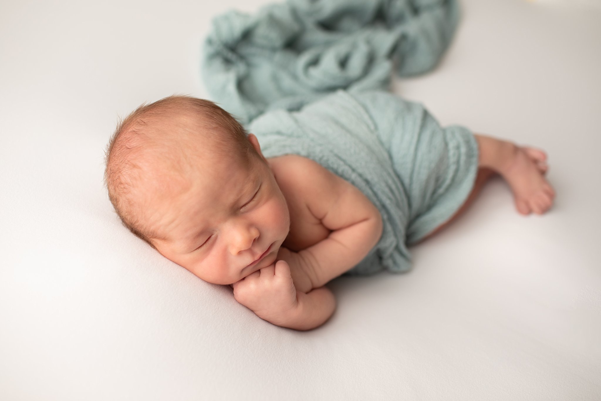 Newborn boy sleeping in wrap