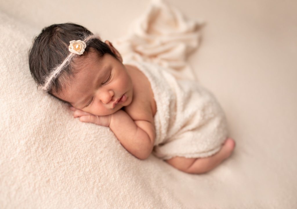 The Kerry Headband in Pale Peach on a newborn lying on tummy