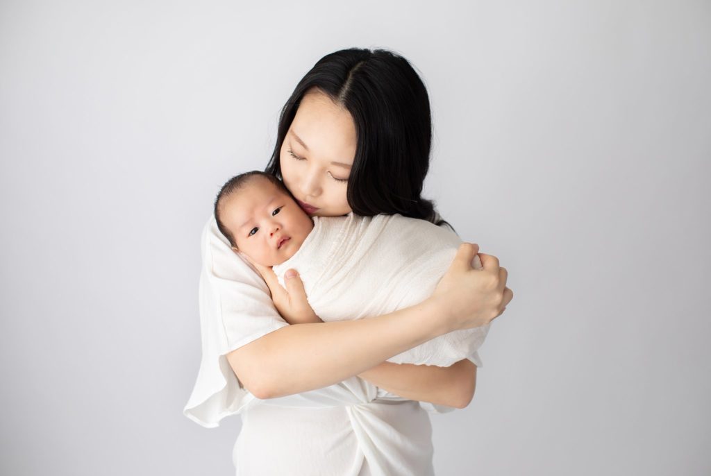 mother holding newborn close
