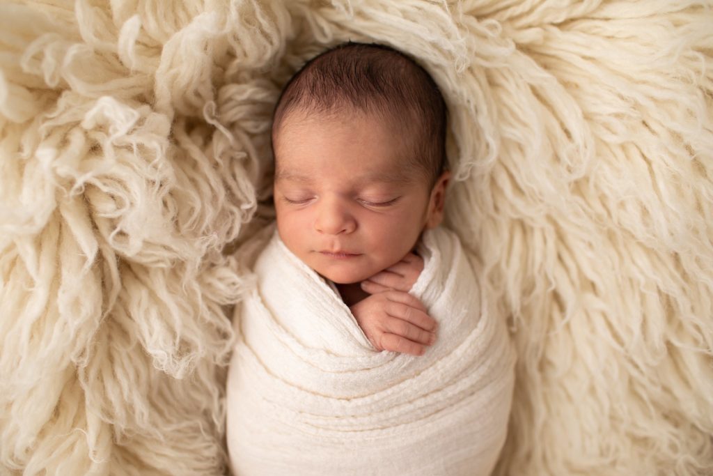 newborn wrapped on flokati