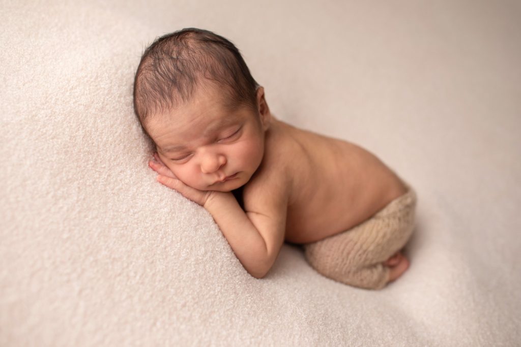 newborn sleeping on soft fabric