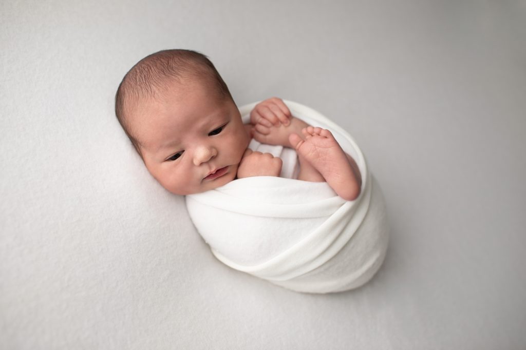 newborn boy wrapped in white wrap