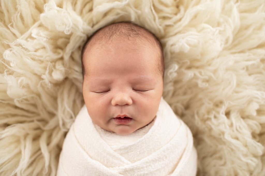newborn boy wrapped in white wrap