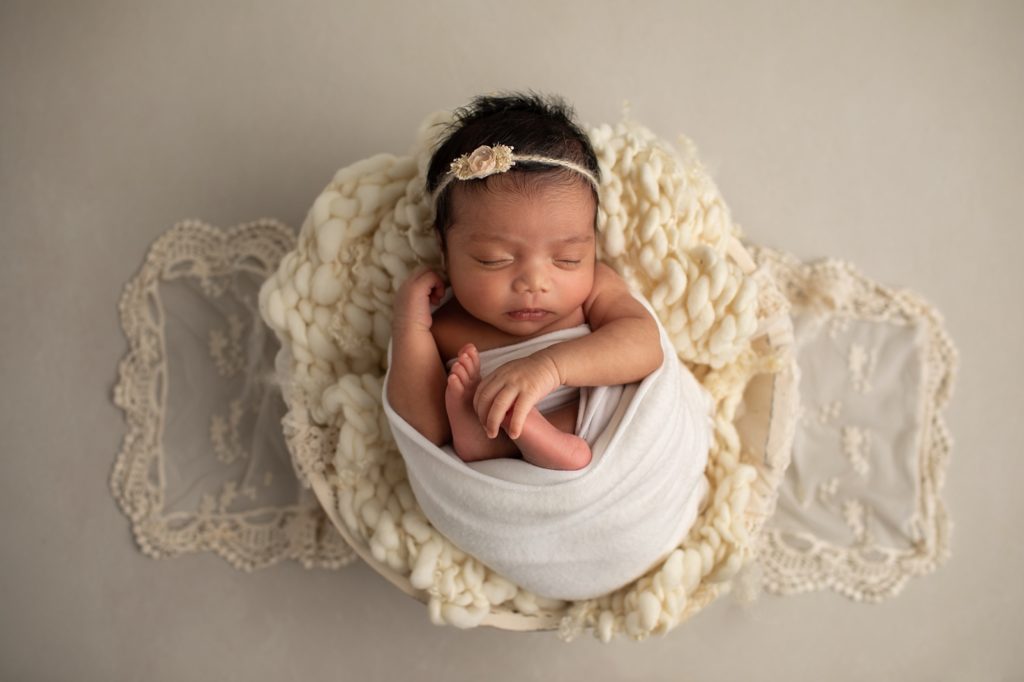 newborn girl wrapped on wool blanket in bowl
