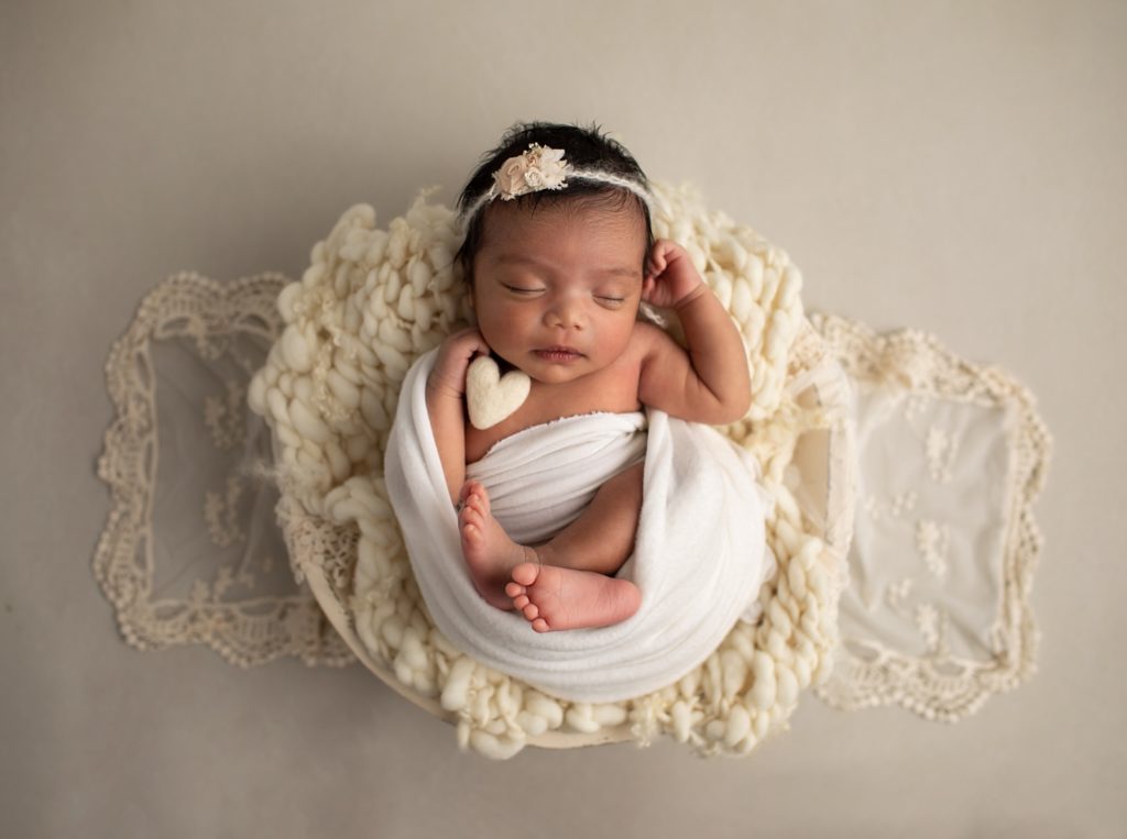 newborn girl wrapped on wool blanket in bowl with a felted heart