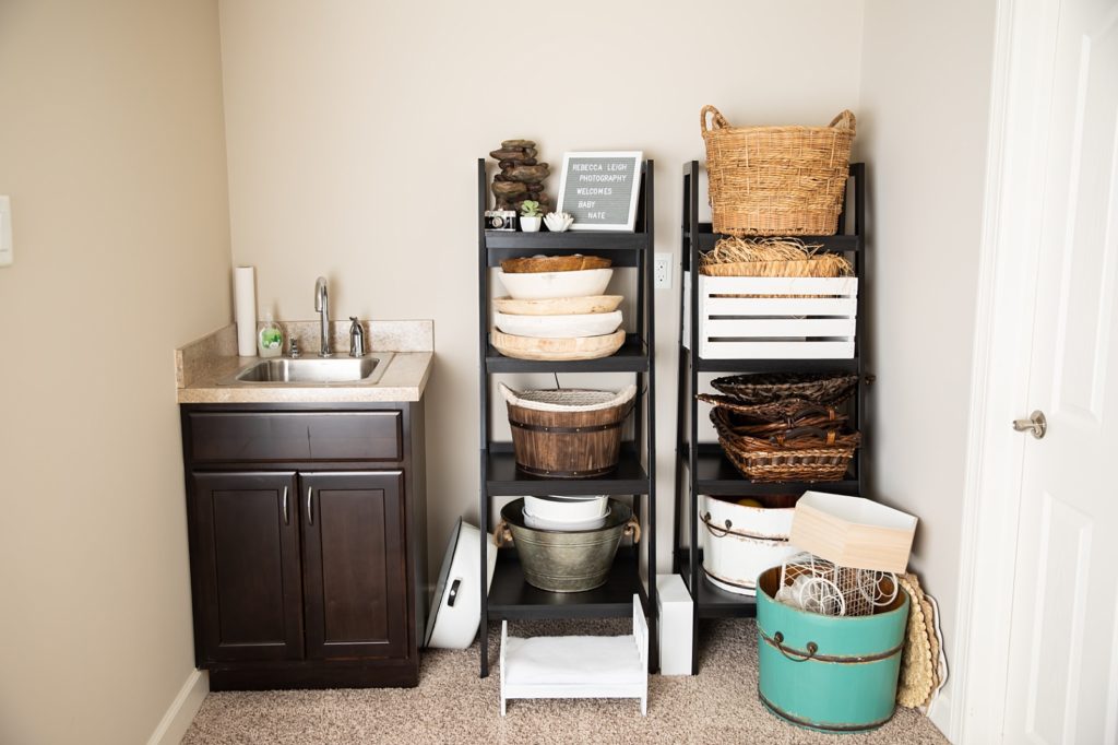 Sink and shelving with a welcome sign and bowls, buckets, and baskets