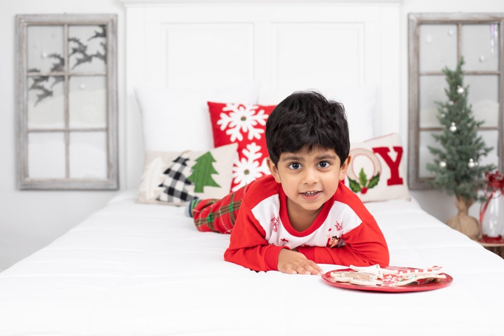 boy smiling on Christmas bed
