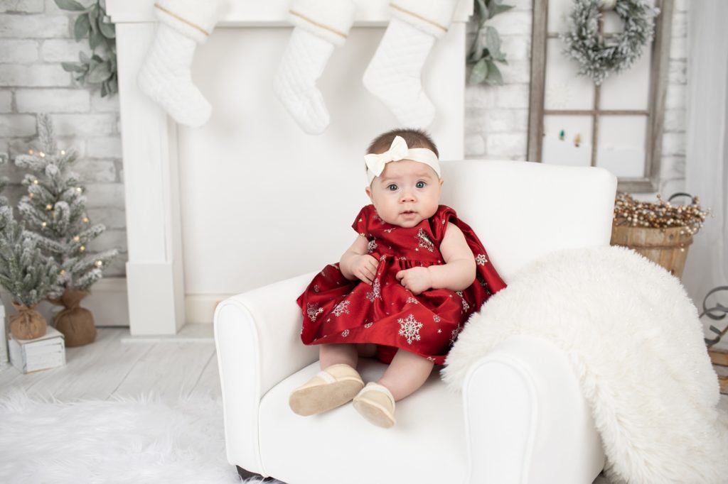 baby girl wearing read dress with white snowflakes

