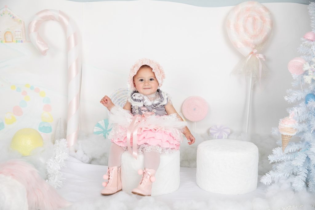 Baby girl wearing a pink, white and gray decorative dress