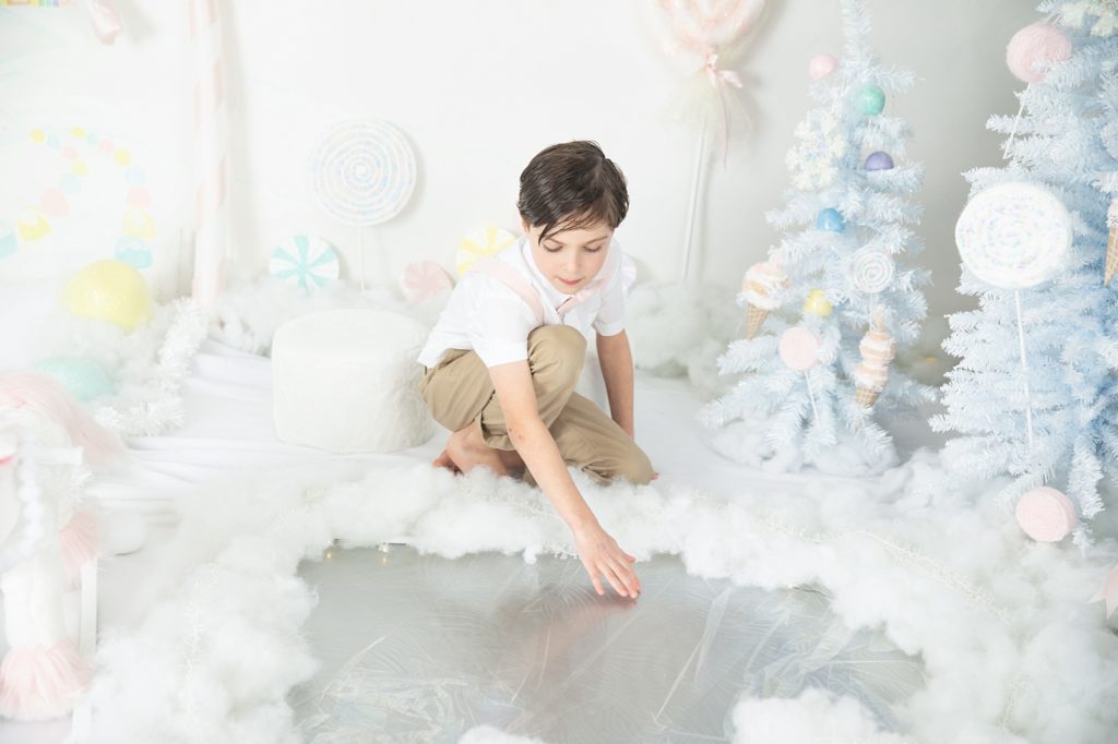 Boy looking at reflection in icy lake in the land of sweets
