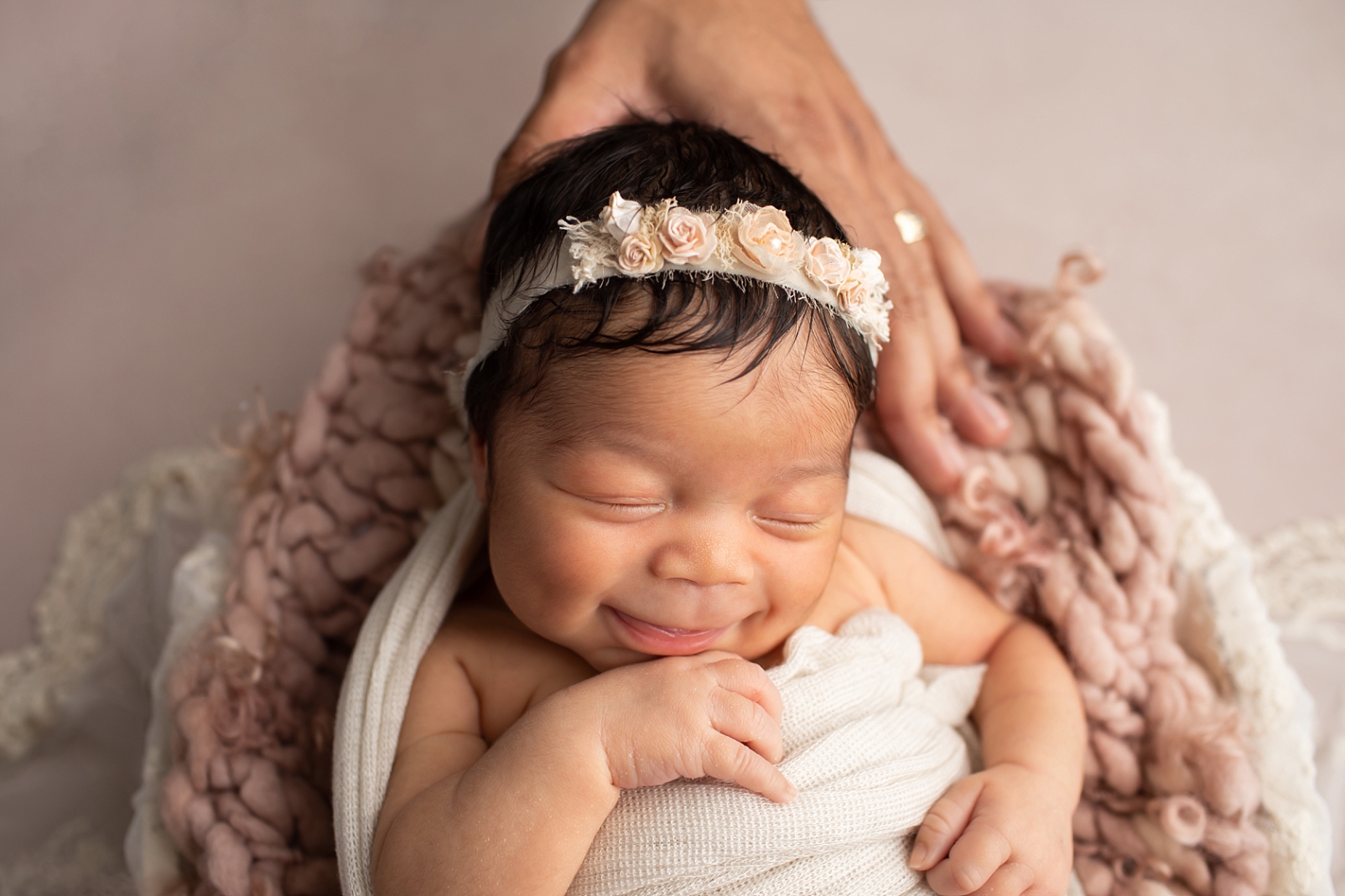 Newborn baby girl smiling with eyes closed