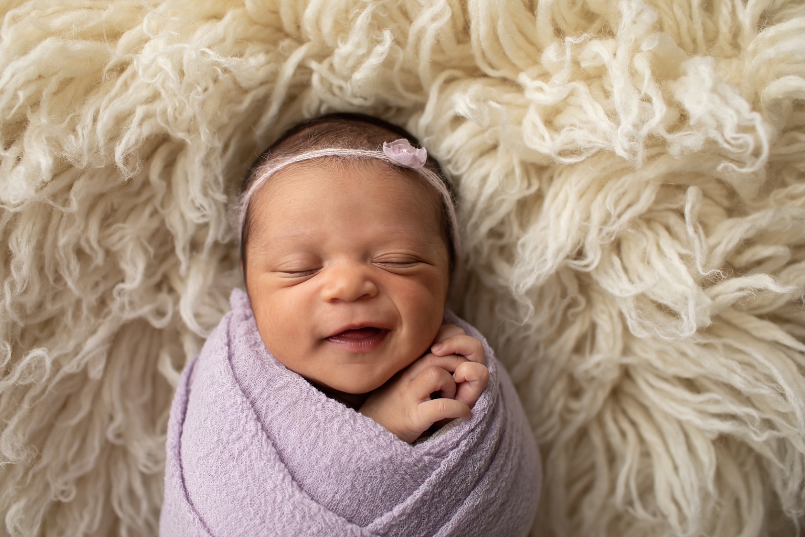newborn girl in lavender and big smile
