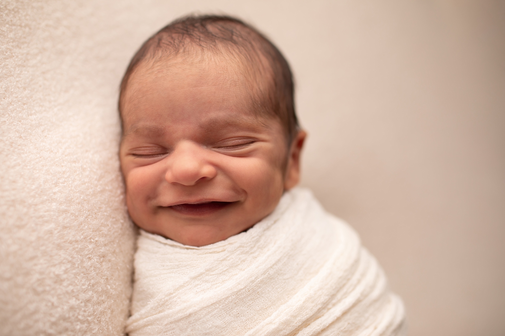 newborn boy with big smile