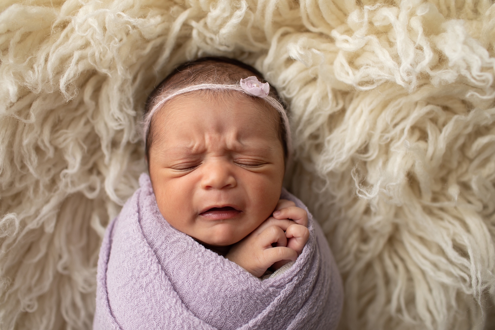 sleeping newborn girl with funny frown

