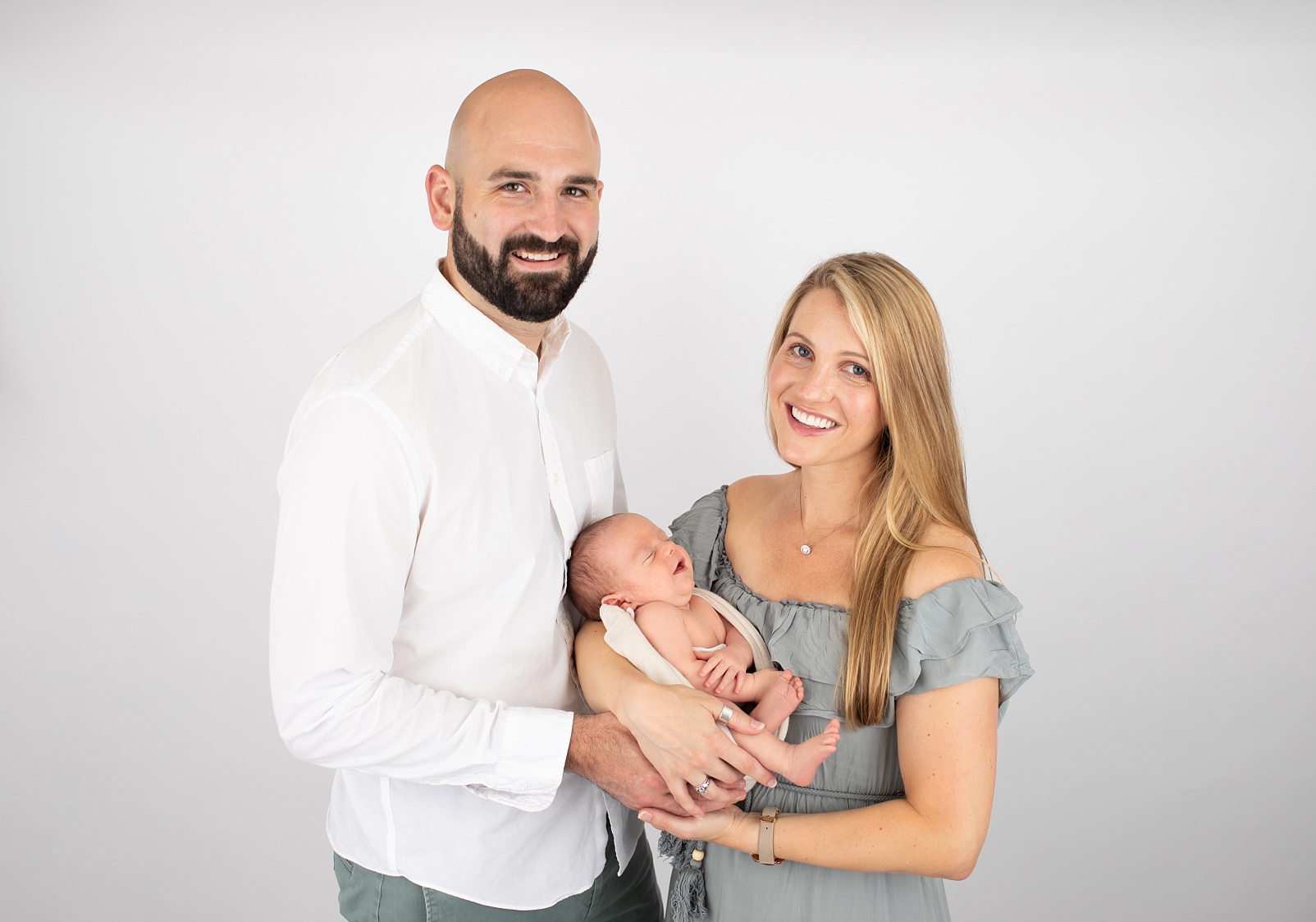 parents holding smiling newborn boy
