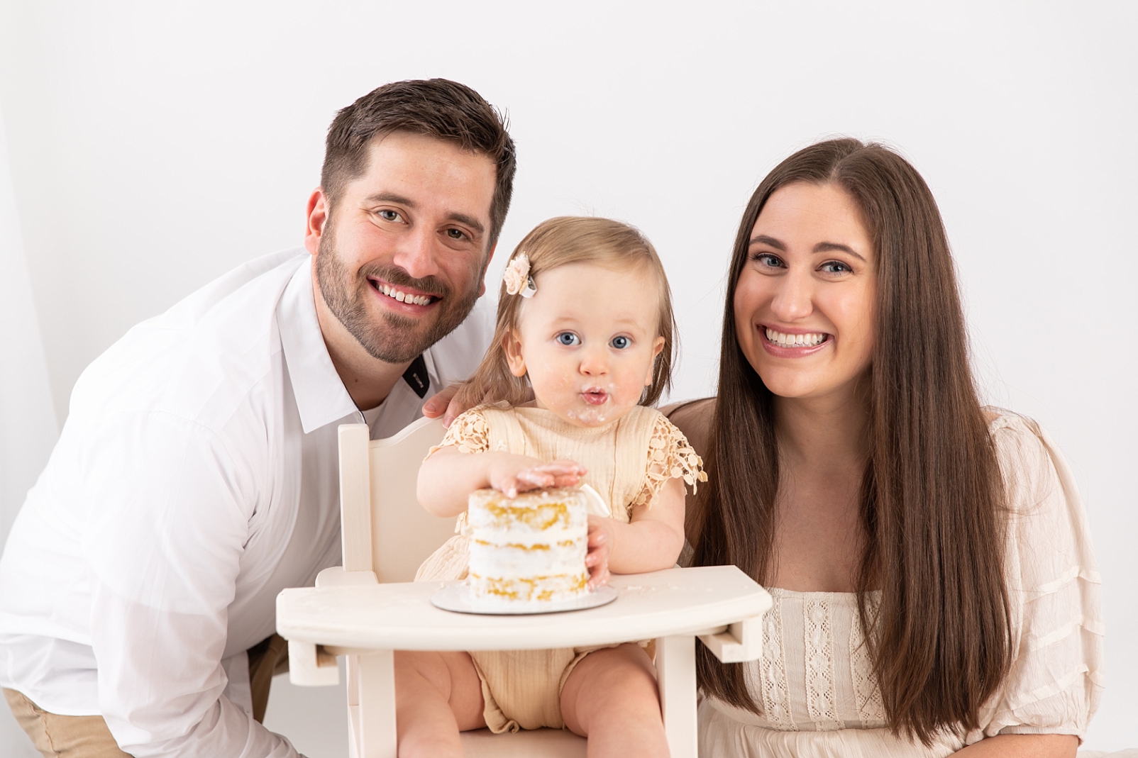baby and parents with cake

