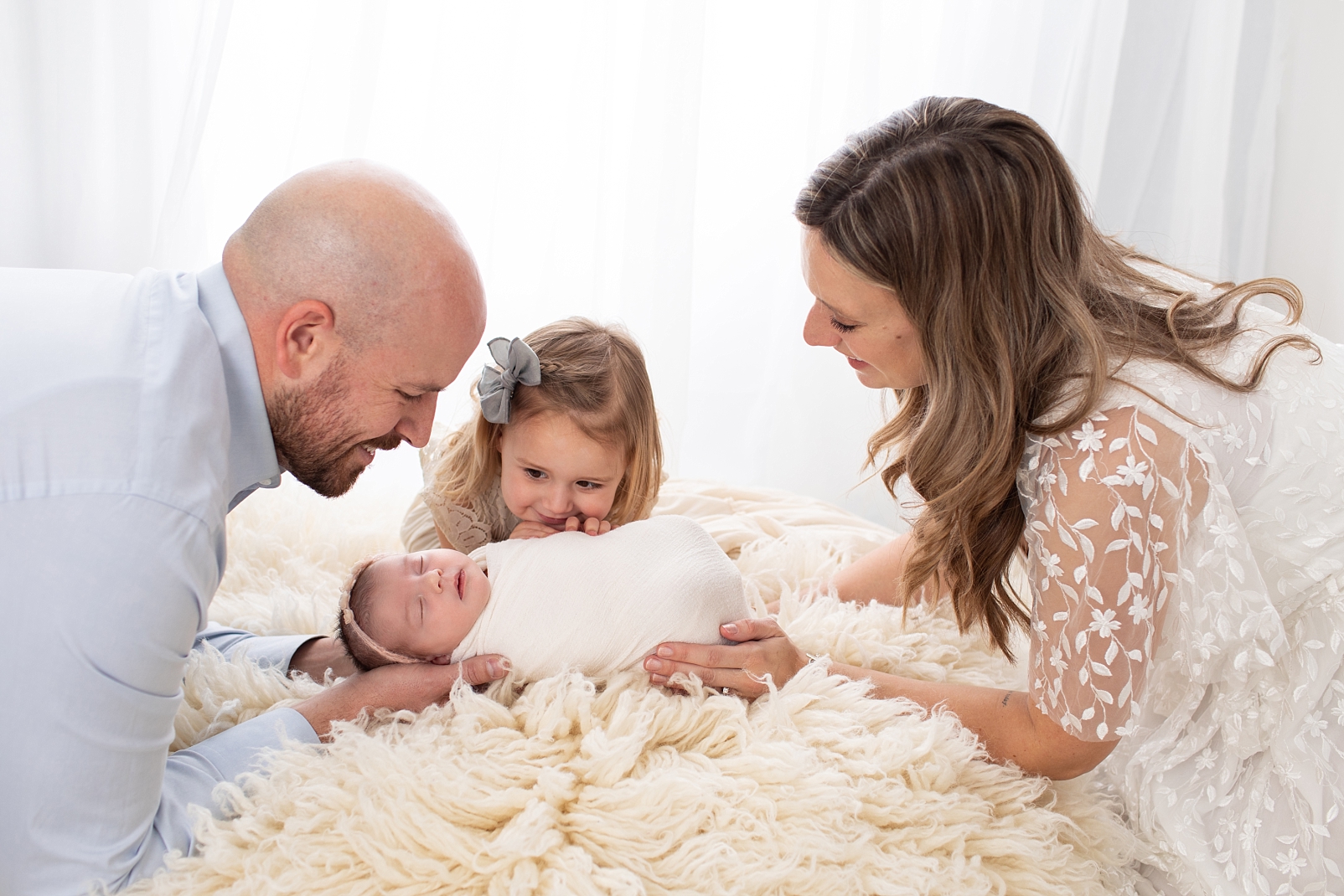 Family looking at their newborn baby in Ellicott City Newborn Photographer in Maryland
