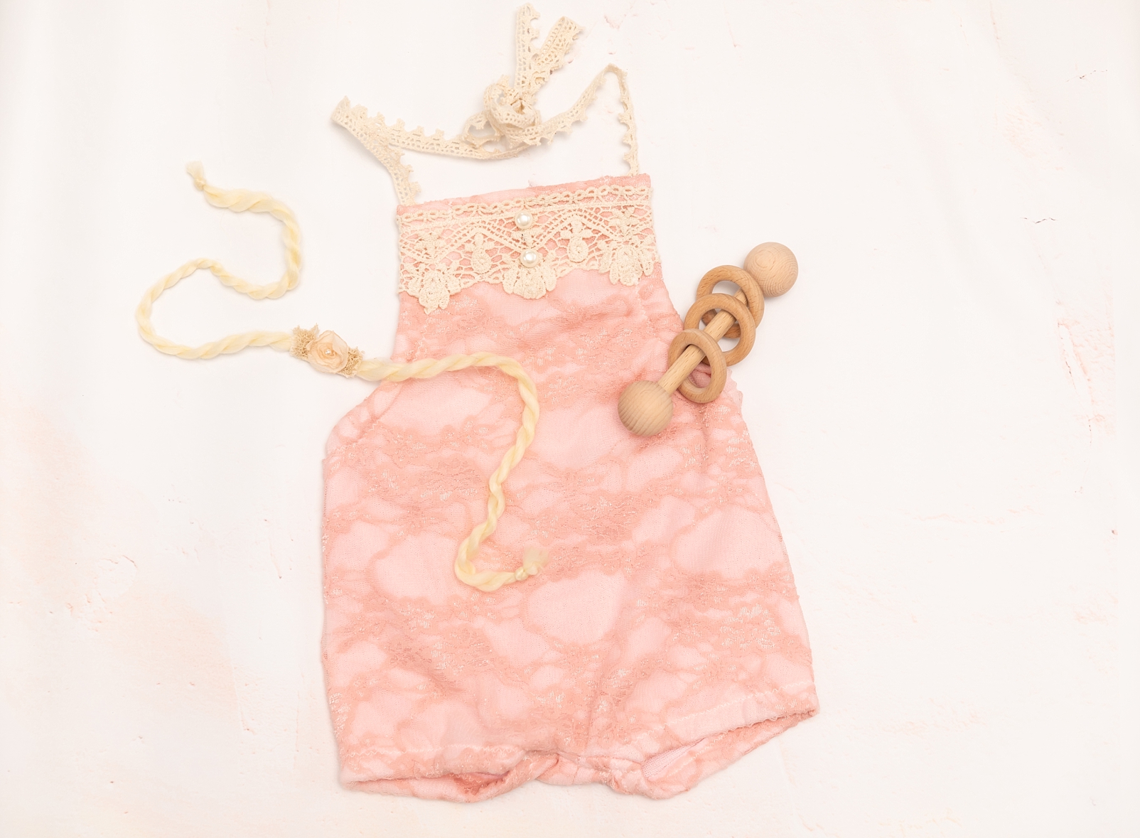 pink lace baby romper with wooden rattle and tieback headband 