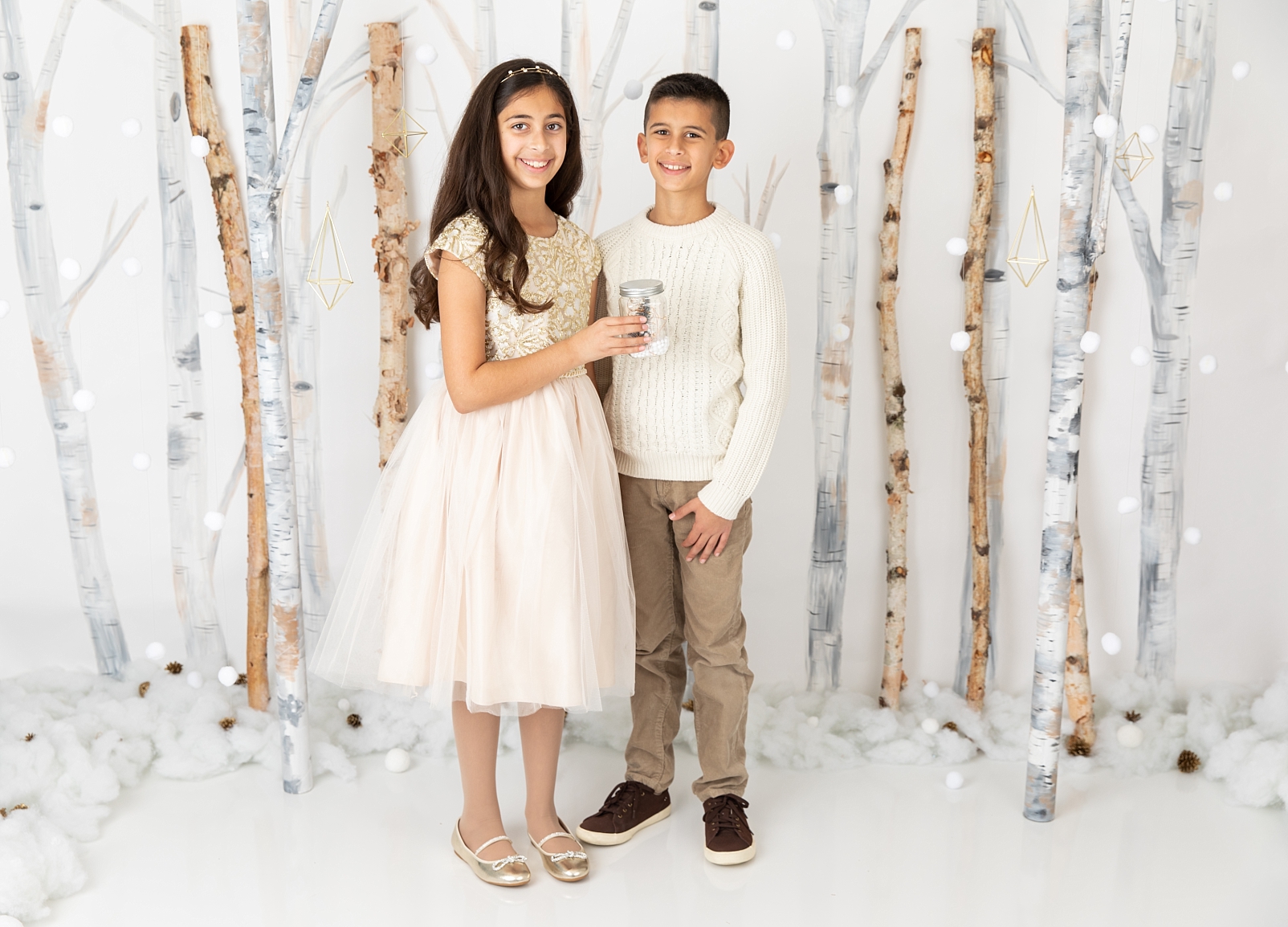 boy and girl standing in front of birch trees and snowballs for Christmas Studio Minis Maryland