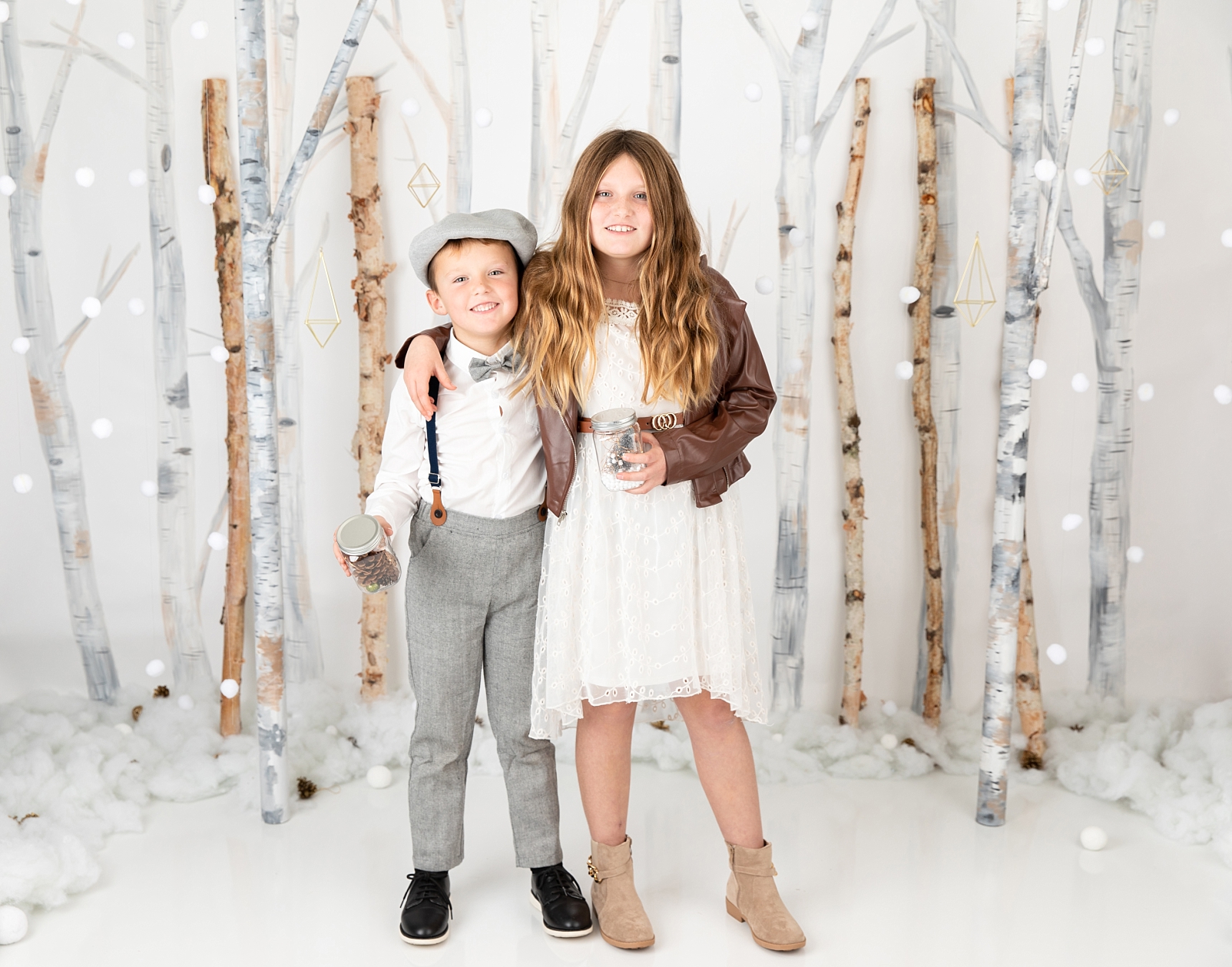 boy and girl standing in front of birch trees and snowballs for Christmas Studio Minis Maryland