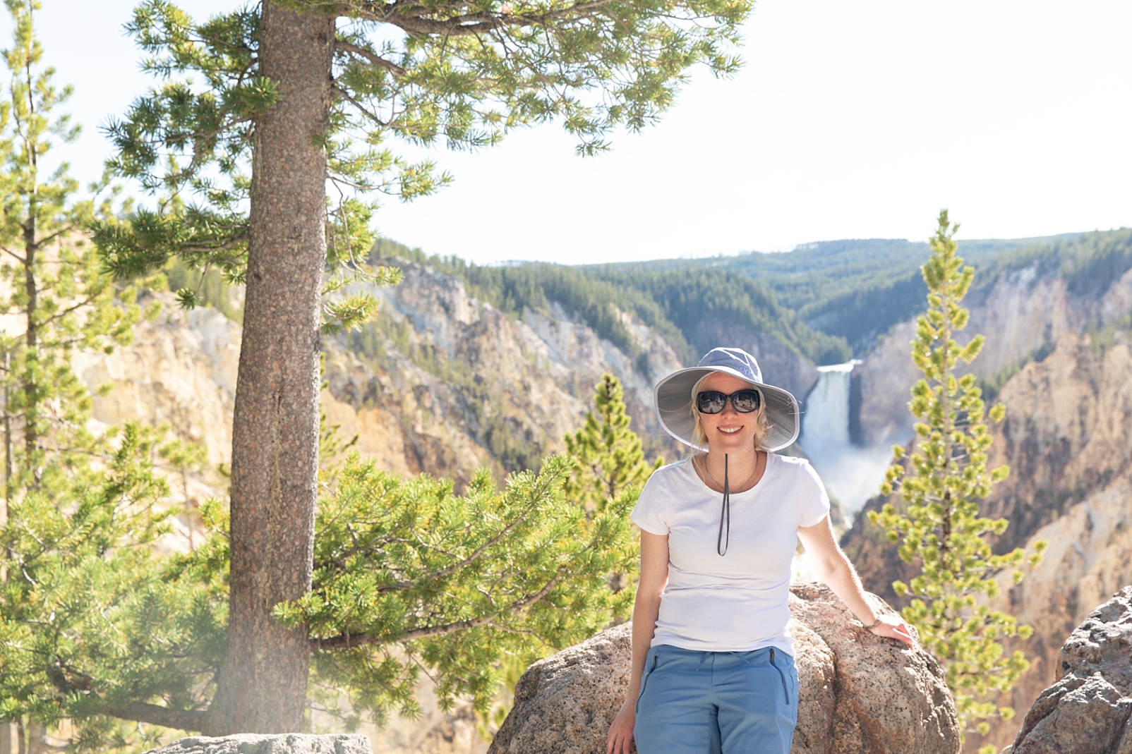Lady wearing sunglasses and a hat in the Grand Canyon of Yellowstone.