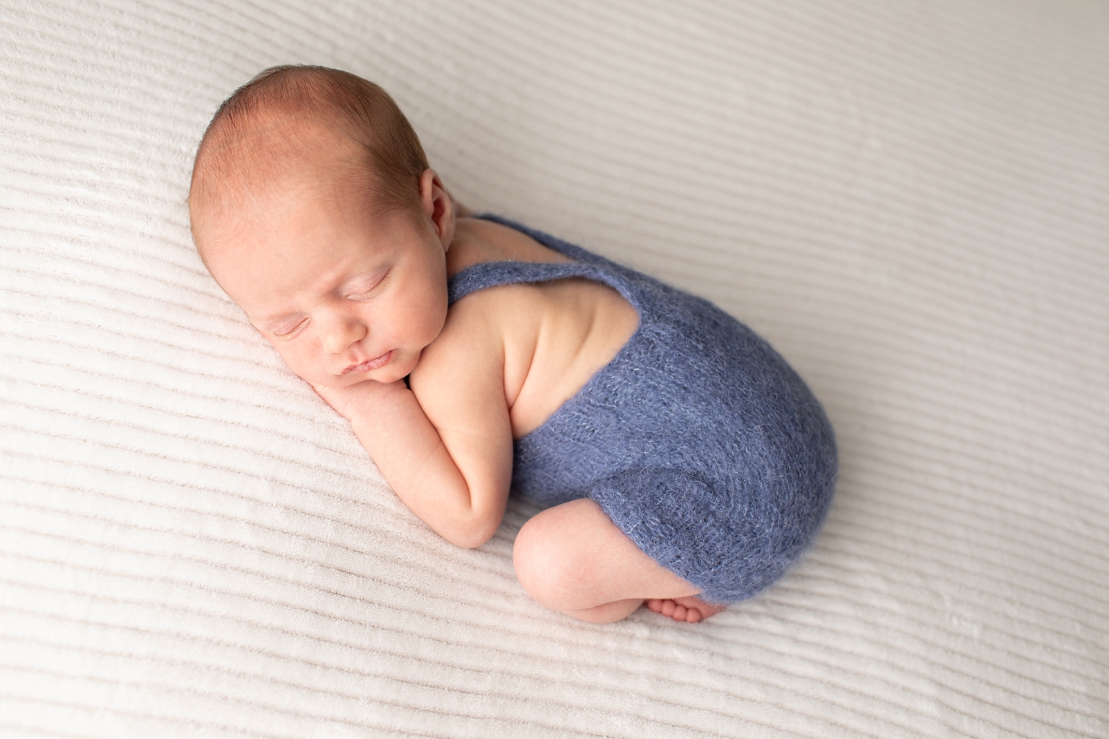 How to choose and download your digital images of a baby in blue overalls on his tummy

