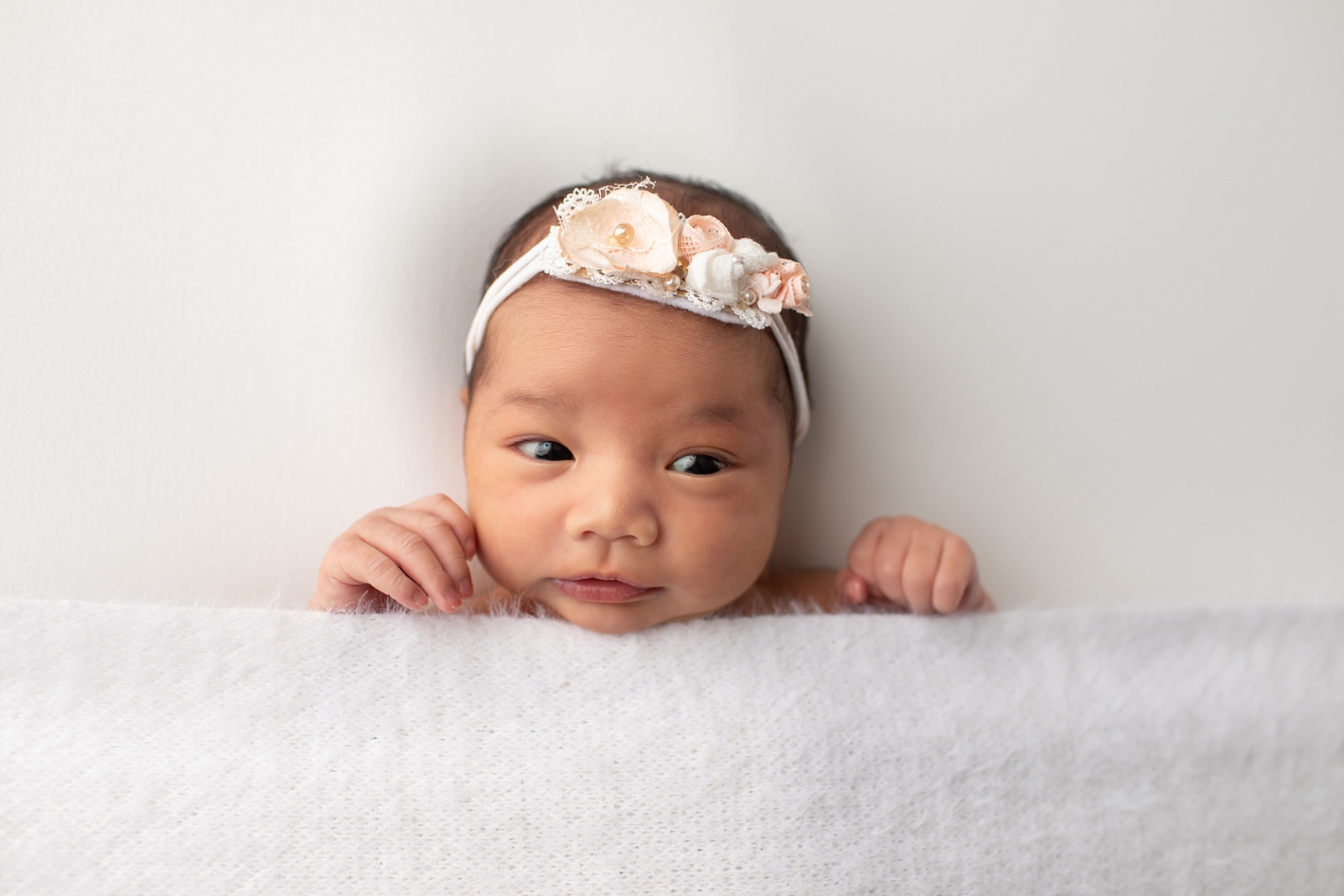 First Year Membership | Maryland Baby Photographer portraits of Newborn baby girl with her eyes open wearing a floral headband