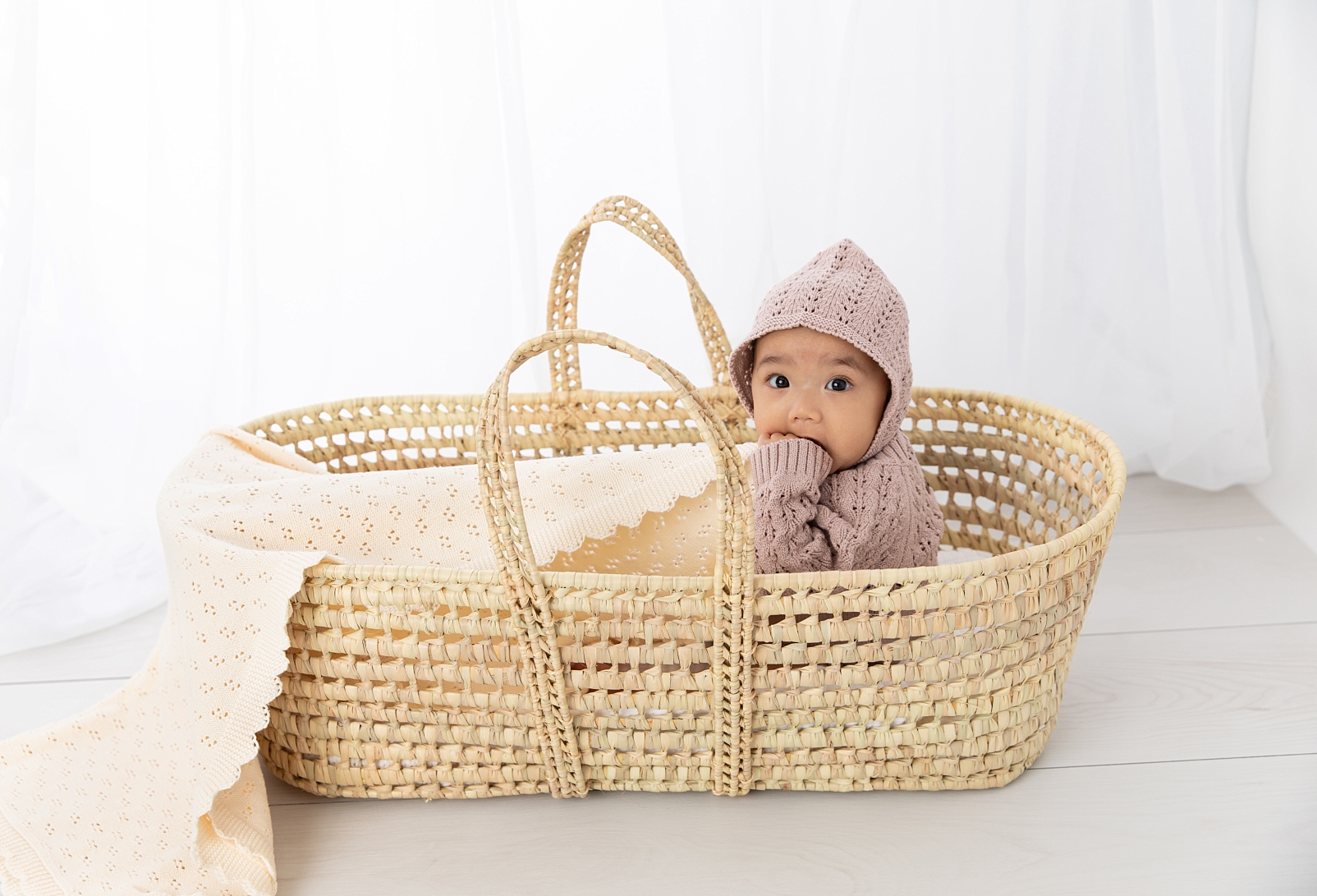 First Year Membership | Maryland Baby Photographer portraits of 7 month old girl in a knit outfit and bonnet sitting in a Moses basket
