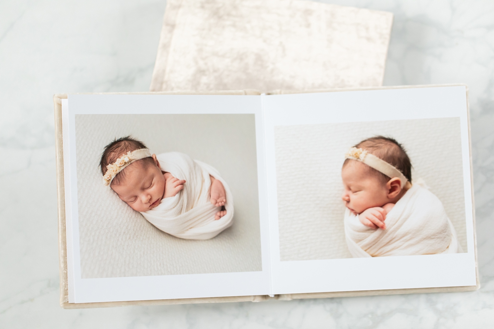 Velvet album open with images of a newborn baby wrapped in a white fabric so that photographs keep our memories