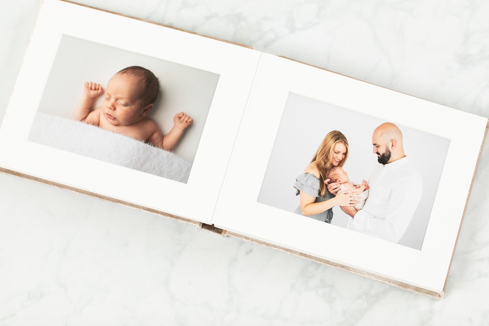 photographs keep our memories in a newborn album with velvet cover showcasing a mom and dad smiling at their baby boy