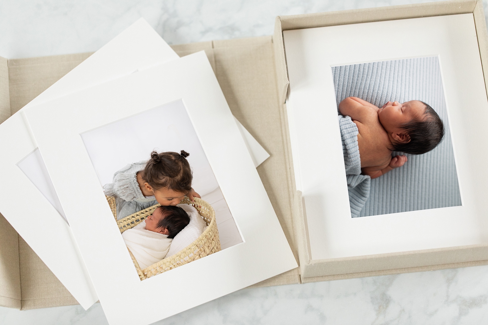 Matter Fine Art Prints box showcasing newborn photos of a girl and her baby brother in a basket