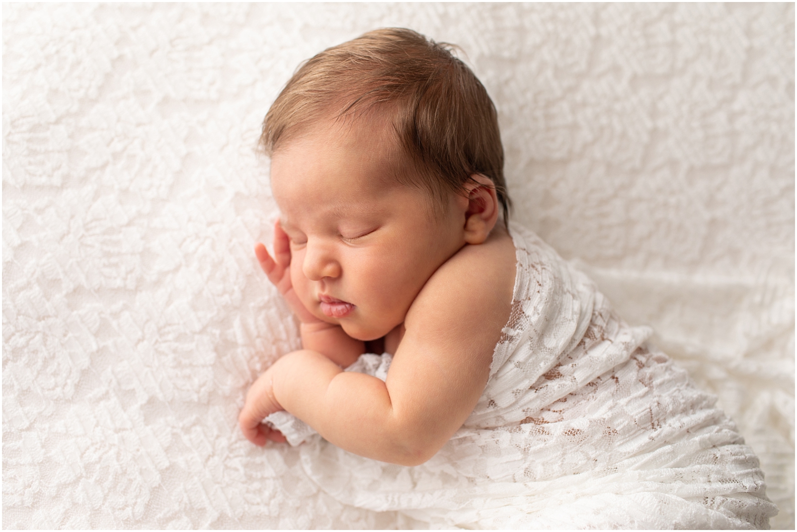 Newborn girl sleeping on a white floral fabric - Rebecca Leigh Photography