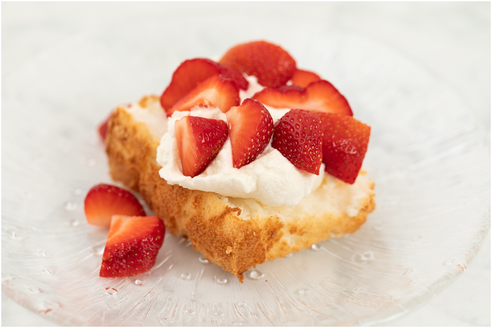 A strawberry shortcake with homemade whipped cream on angel food cake
