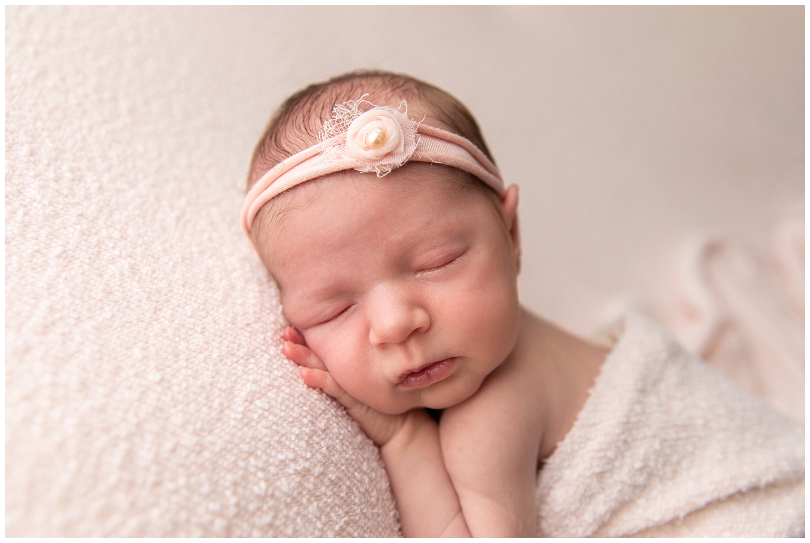 Newborn girl close-up photo with floral pink headband