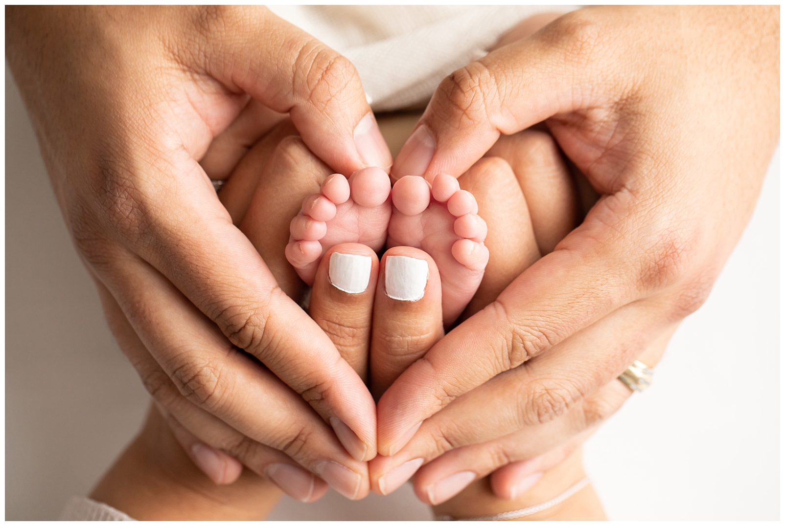 Mom and dad hands holding a baby's toes